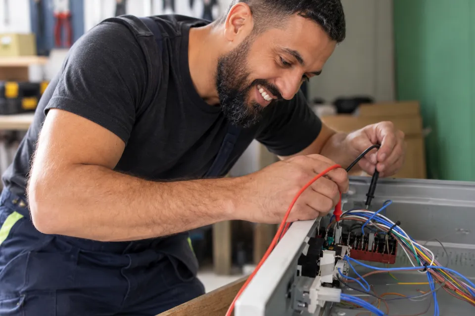 Technicien Fix and Furious contrôlant le câblage d'un appareil électroménager
